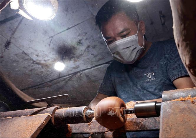 Nghệ nhân đứng máy tiện gỗ. Ảnh: Trần Việt - TTXVN