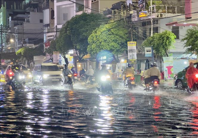 Người dân vất vả di chuyển trên đường Hà Hoàng Hổ, thành phố Long Xuyên, An Giang ngập sâu trong nước. Ảnh: Thanh Sang-TTXVN