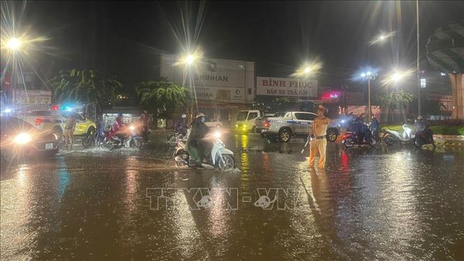 Cảnh sát giao thông, công an tỉnh Bình Phước điều tiết khu vực ngập lụt, tránh ách tắc. Ảnh: TTXVN phát
