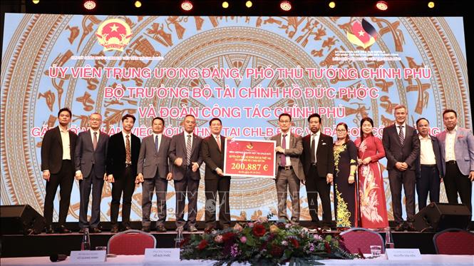 Đại diện Liên hiệp hội Người Việt Nam tại CHLB Đức trao hơn 200.000 euro cho Phó Thủ tướng Chính phủ Hồ Đức Phớc (thứ sáu từ trái) chuyển về ủng hộ đồng bào bão lụt trong nước. Ảnh: Phương Hoa - P/V TTXVN tại CHLB Đức
