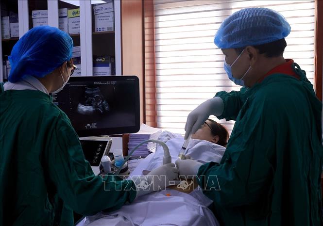 Chọc hút dịch ối làm nhiễm sắc thể đồ và các xét nghiệm phân tử. Ảnh: Tuấn Anh - TTXVN