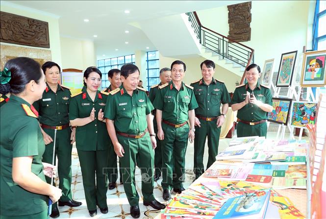 Thượng tướng Lê Huy Vịnh, Thứ trưởng Bộ Quốc phòng và các đại biểu tham quan gian trưng bày sách, báo, ấn phẩm về sự tiến bộ của phụ nữ. Ảnh: Trọng Đức - TTXVN