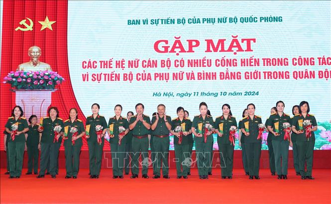 Thượng tướng Lê Huy Vịnh, Thứ trưởng Bộ Quốc phòng và Trung tướng Lê Quang Minh, Phó Chủ nhiệm Tổng cục Chính trị QĐND Việt Nam trao biểu trưng và hoa tặng các nữ đại biểu xuất sắc. Ảnh: Trọng Đức - TTXVN
