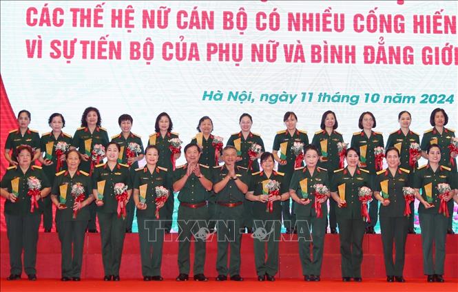 Thượng tướng Lê Huy Vịnh, Thứ trưởng Bộ Quốc phòng và Trung tướng Lê Quang Minh, Phó Chủ nhiệm Tổng cục Chính trị QĐND Việt Nam trao biểu trưng và hoa tặng các nữ đại biểu xuất sắc. Ảnh: Trọng Đức - TTXVN