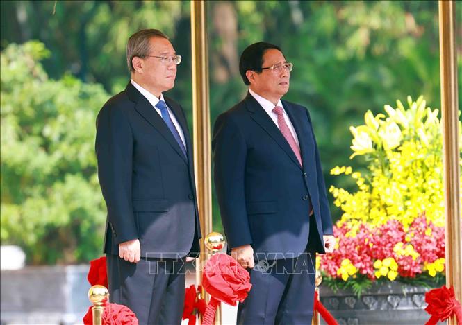 Thủ tướng Phạm Minh Chính và Thủ tướng Trung Quốc Lý Cường trên bục danh dự, nghe quân nhạc cử Quốc thiều hai nước. Ảnh: Dương Giang - TTXVN
