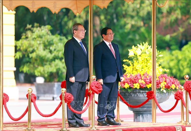 Thủ tướng Phạm Minh Chính và Thủ tướng Trung Quốc Lý Cường trên bục danh dự, nghe quân nhạc cử Quốc thiều hai nước. Ảnh: Dương Giang - TTXVN
