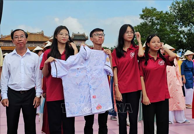 Lời chúc của thầy cô, bạn bè trên chiếc áo trắng là món quà động viên Phú Đức trước giờ bước vào cuộc thi. Ảnh: Tường Vi - TTXVN.       