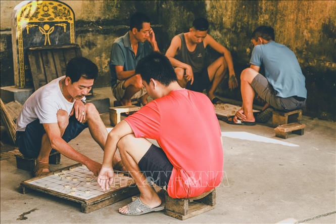 Những người dân làng tụ tập chơi cờ tướng, một hoạt động văn hóa truyền thống của cộng đồng nơi đây. Ảnh: Vân Chi/TTXVN phát

