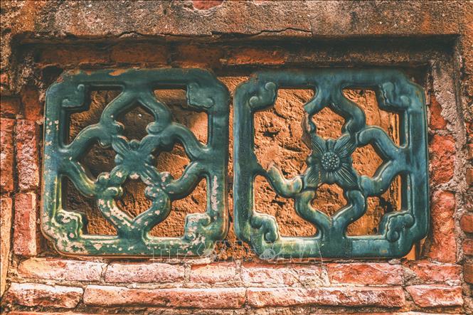 Bức tường gạch với ô cửa xanh ngọc, được chạm khắc hoa văn mang nét kiến trúc Á Đông. Ảnh: Vân Chi/TTXVN phát

