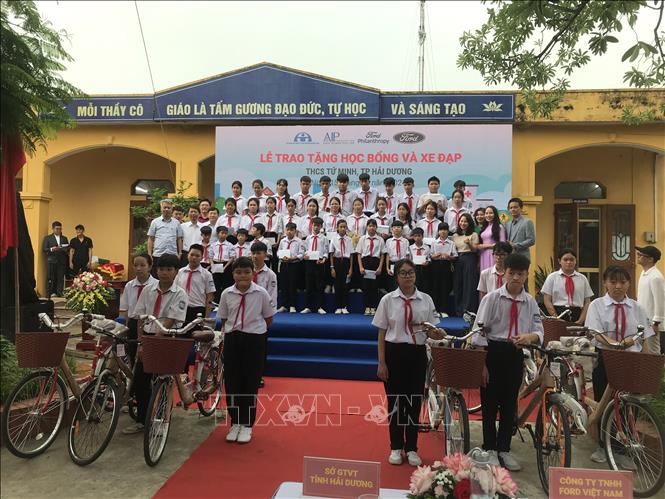 Ban tổ chức trao tặng học bổng và xe đạp cho các học sinh có hoàn cảnh đặc biệt nhưng đã cố gắng vươn lên. Ảnh: Tiến Vĩnh – TTXVN