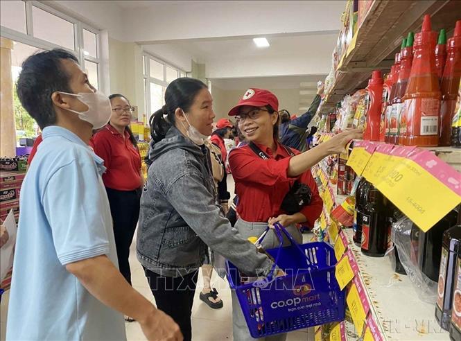 Nhân viên Hội Chữ thập đỏ thành phố Đà Nẵng hỗ trợ người dân nghèo lựa chọn các nhu yếu phẩm tại chương trình Tết Nhân ái 