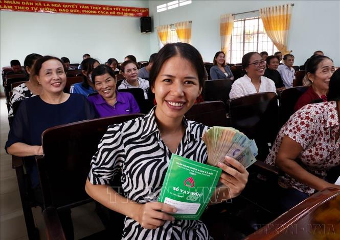 Người dân vui mừng nhận tiền vốn vay từ điểm giao dịch Ngân hàng Chính sách xã hội tỉnh Đồng Nai. Ảnh: Hồng Đạt - TTXVN