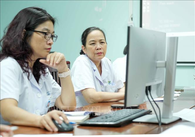 Tiến sĩ, Bác sĩ cao cấp Bùi Ngọc Lan (bên phải) hội chẩn bệnh tại Trung tâm Ung thư. Ảnh: Phương Hoa - TTXVN