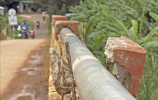 Lan can cây cầu tại thôn Đà Thuận (xã Đà Loan, huyện Đức Trọng) bị hư hại, lộ sắt nhọn tiềm ẩn nguy cơ mất an toàn cho người dân khi đi qua đây. Ảnh: Nguyễn Dũng - TTXVN