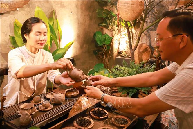 Chị Lâm Diệu Linh rót trà mời khách. Ảnh: Vân Chi/TTXVN phát