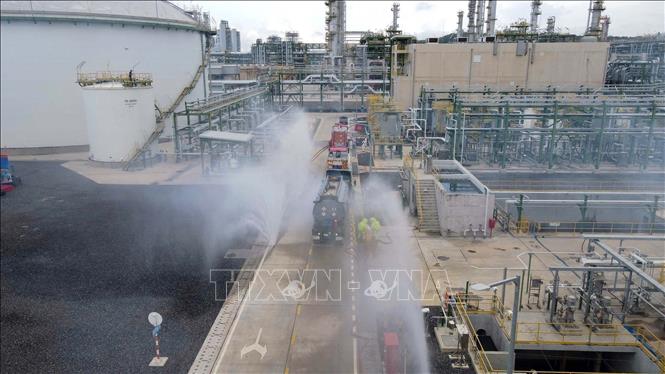 Phun nước hạn chế phát tán axit HCl ra không khí. Ảnh: Đoàn Mạnh Dương-TTXVN