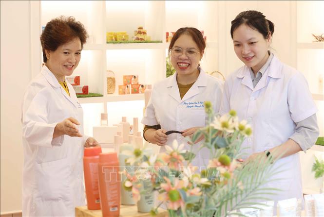Chị Nguyễn Thị Hương Liên (bên trái) cùng các dược sĩ tại phòng trưng bày sản phẩm của công ty. Ảnh: Phương Hoa - TTXVN