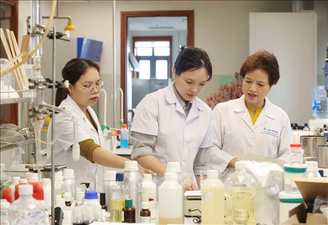 Chị Nguyễn Thị Hương Liên (bên phải) cùng các dược sĩ tại phòng nghiên cứu của công ty. Ảnh: Phương Hoa - TTXVN