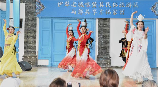 Những cô gái, chàng trai dân tộc thiểu số đội bát và ấm trà trên đầu nhảy múa khi có khách quý đến chơi. Ảnh: Quang Hưng-Pv TTXVN tại Trung Quốc