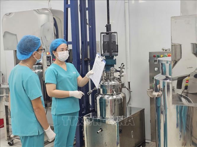 Chị Trịnh Thị Bích Linh (thứ 2, bên trái) kiểm tra chất lượng sản phẩm tại nhà máy sản xuất mỹ phẩm. Ảnh: Phương Hoa - TTXVN