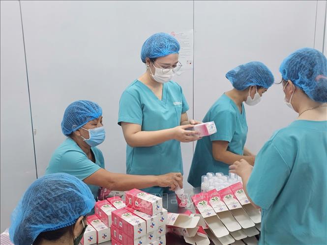 Chị Trịnh Thị Bích Linh (giữa) kiểm tra chất lượng sản phẩm tại nhà máy sản xuất mỹ phẩm. Ảnh: Phương Hoa - TTXVN