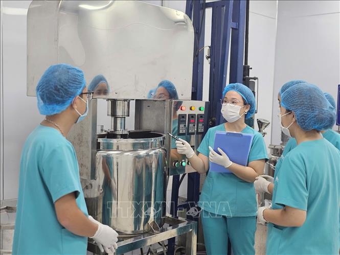 Chị Trịnh Thị Bích Linh (giữa) kiểm tra chất lượng sản phẩm tại nhà máy sản xuất mỹ phẩm. Ảnh: Phương Hoa - TTXVN