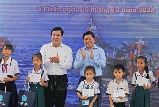 Phó Tổng biên tập Báo Pháp Luật Thành phố Hồ Chí Minh Nguyễn Thái Bình (trái) và Phó Chủ tịch UBND tỉnh Cà Mau Lê Văn Sử trao học bổng cho học sinh là con gia đình ngư dân vượt khó học giỏi. Ảnh: Huỳnh Anh - TTXVN