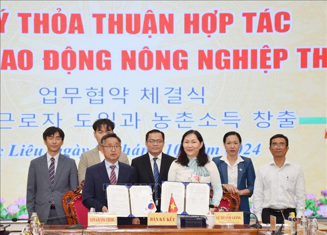 Giám đốc sở Lao động, Thương binh và Xã hội tỉnh Bạc Liêu Lê Thanh Giang và ông Kim Gwang Cheol, Cục trưởng Cục kinh tế du lịch, nông nghiệp huyện Uiseong (USal), tỉnh Gyeongsangbuk-do ký kết thỏa thuận hợp tác đưa lao động sang Hàn Quốc làm việc. Ảnh: TTXVN phát.