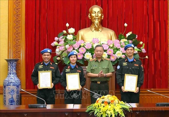 Thừa ủy quyền của Chủ tịch nước, Đại tướng Tô Lâm, Bộ trưởng Bộ Công an, trao Quyết định của Chủ tịch nước cho 3 sĩ quan đi thực hiện nhiệm vụ gìn giữ hoà bình LHQ tại Nam Sudan (10/10/2022). Ảnh: TTXVN phát