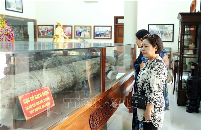 Du khách tham quan hiện vật cọc Bạch Đằng được bảo tồn nguyên trạng tại khu di tích. Ảnh: Hoàng Hiếu - TTXVN