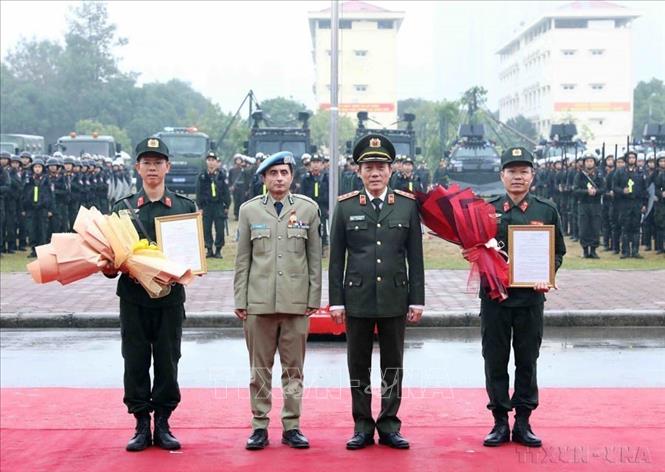 Thượng tướng Lương Tam Quang, Thứ trưởng Bộ Công an và Tư lệnh Cảnh sát Liên hợp quốc về hợp tác trên lĩnh vực gìn giữ hòa bình Faisal Shahkar trao quyết định thành lập Đơn vị Cảnh sát gìn giữ hoà bình số 1 (11/1/2024). Ảnh: Phạm Kiên - TTXVN