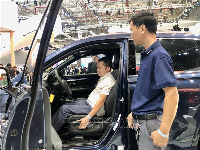 Visitors experience a new car model at the event. VNA Photo: Mỹ Phương