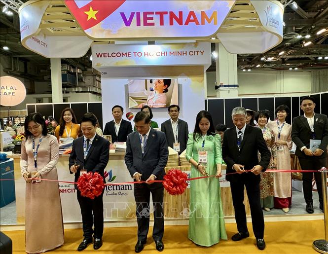 Đại sứ Mai Phước Dũng (giữa) cắt băng khai trương gian hàng du lịch TP Hồ Chí Minh tại hội chợ. Ảnh: Đỗ Vân-PV TTXVN tại Singapore