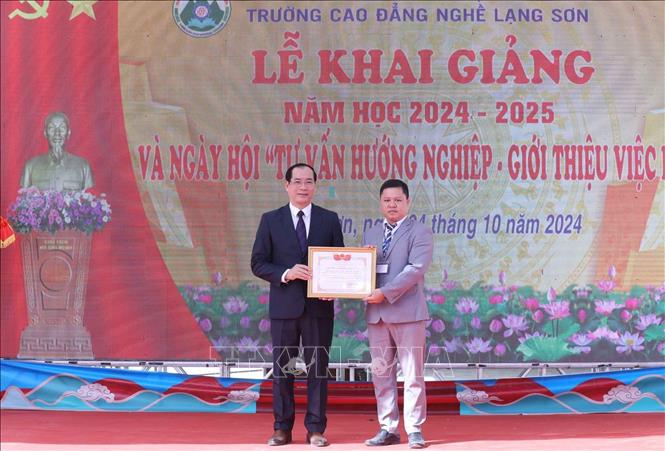 Phó Chủ tịch Thường trực UBND tỉnh Lạng Sơn Dương Xuân Huyên trao Bằng khen của Chủ tịch UBND tỉnh Lạng Sơn cho 1 tập thể khoa của trường Cao đẳng nghề Lạng Sơn. Ảnh: Anh Tuấn – TTXVN