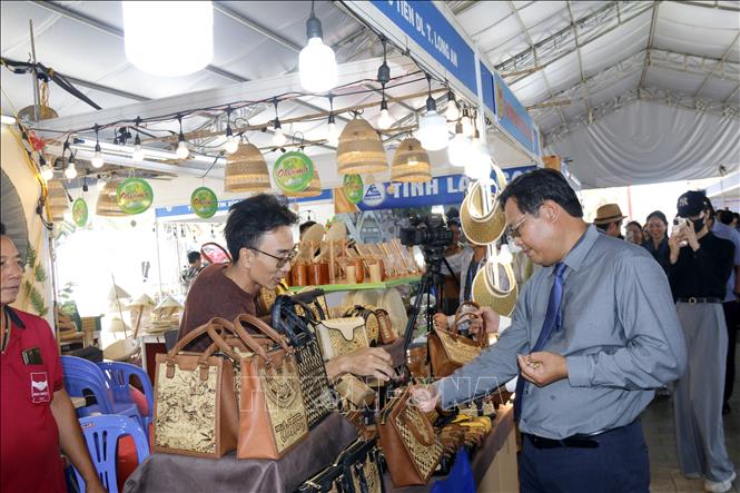 Đại biểu tham quan không gian trưng bày, giới thiệu, quảng bá sản phẩm du lịch, đặc sản vùng miền, sản phẩm OCOP của tỉnh Long An. Ảnh: Nguyễn Thanh - TTXVN
