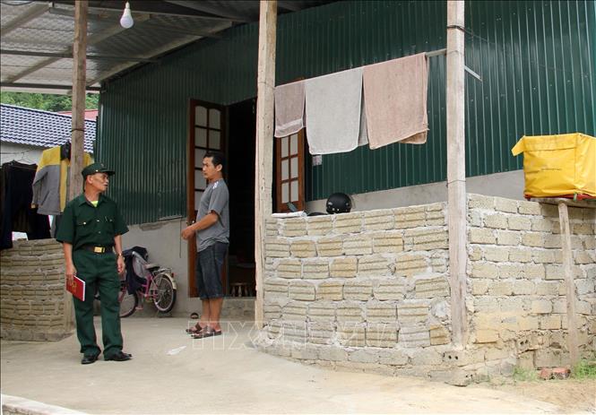Gia đình anh Lô Thanh Tâm (bên phải) tại bản Hoa Sơn, xã Tà Cạ (Kỳ Sơn, Nghệ An) đã dựng lại căn nhà ở tạm, chờ ngày tái định cư. Ảnh: Văn Tý - TTXVN