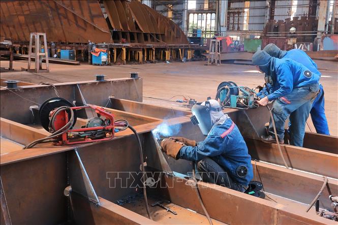 Công nhân Công ty TNHH MTV Đóng tàu Nam Triệu thực hiện đóng mới tàu theo đơn đặt hàng. Ảnh: Hoàng Hiếu - TTXVN