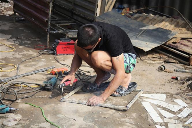 Người dân sửa chữa vật dụng bị hư hỏng. Ảnh: Phương Thảo/TTXVN phát