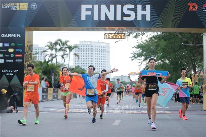 Các VĐV tham dự cự ly 42km và 21km về đích. Ảnh: Minh Quyết - TTXVN
