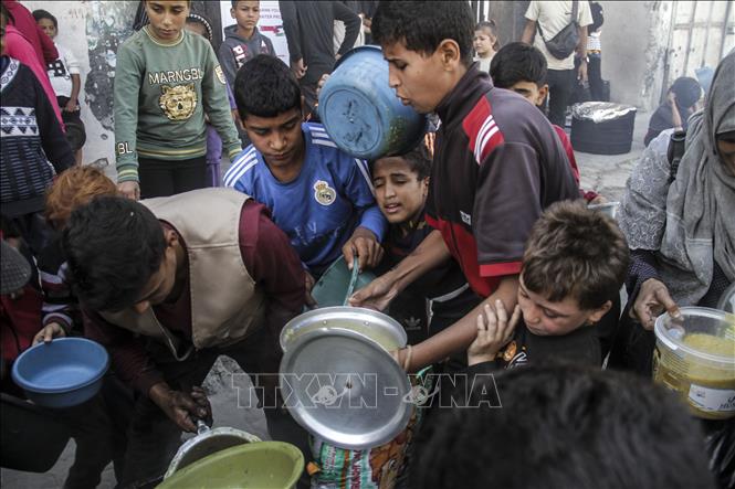 Người dân nhận thức ăn cứu trợ tại thành phố Gaza ngày 23/10/2024. Ảnh: THX/TTXVN