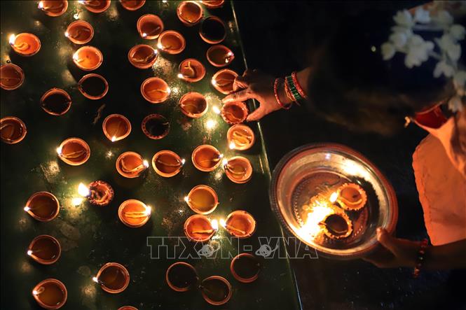 Một tín đồ Hindu thắp đèn dầu trong lễ hội Diwali ở Colombo, Sri Lanka đêm 31/10/2024. Ảnh: THX/TTXVN