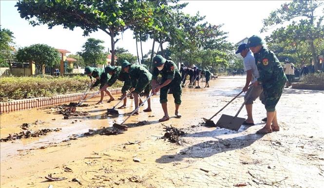 Những lớp bùn bám dày tại các sân trường sau khi nước lũ rút khiến công tác dọn dẹp vệ sinh gặp nhiều khó khăn. Ảnh: TTXVN phát