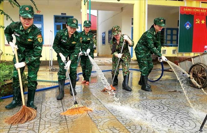 Hội phụ nữ Bộ đội Biên phòng Quảng Bình tích cực tham gia hỗ trợ dọn dẹp vệ sinh tại trường Mầm non và trường THCS Phong Thủy, huyện Lệ Thủy. Ảnh: TTXVN phát