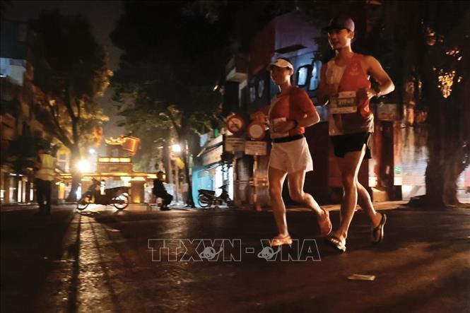 Các VĐV chạy qua phố Trần Nhật Duật (quận Hoàn Kiếm). Ảnh: Minh Quyết - TTXVN