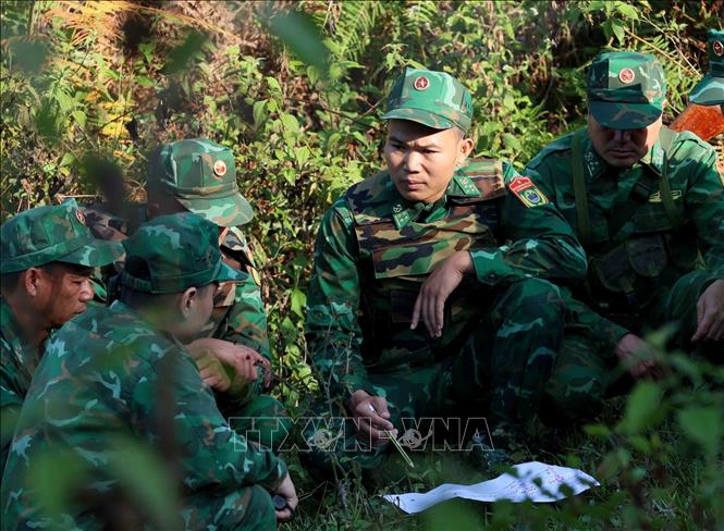 Đại úy Vũ Văn Cường (thứ hai, từ phải sang) cùng đồng đội trong tổ đánh án trao đổi trước khi triển khai phương án vây bắt tội phạm ma túy. Ảnh: An Đăng - TTXVN