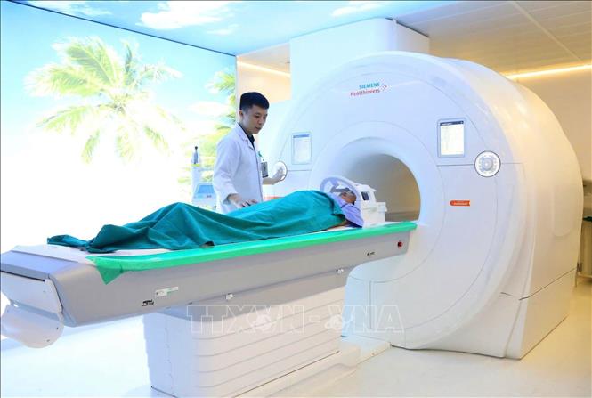 Các y, bác sĩ vận hành hoạt động máy chụp cộng hưởng từ 3.0T để chụp cho các người bệnh. Ảnh: TTXVN phát 