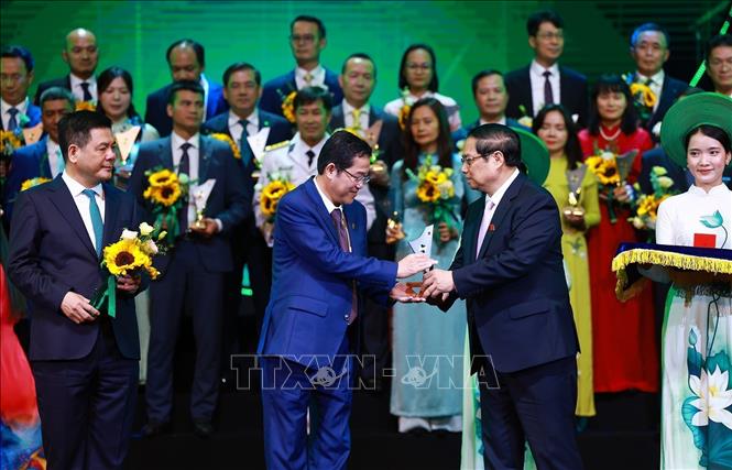 Prime Minister Pham Minh Chinh hands over the Vietnam National Brand status to 190 enterprises with a total of 359 products. VNA Photo: Dương Giang