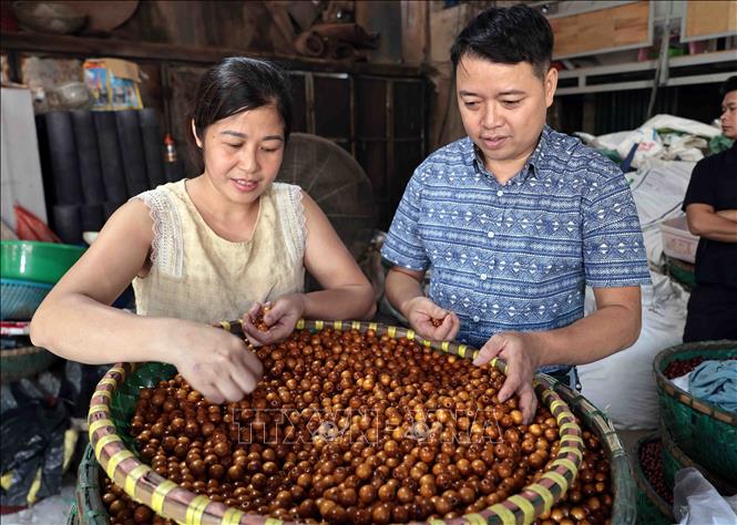 Wooden beads are polished and can be used for making mats or curtains. VNA Photo: Trần Việt