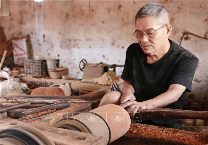 An artisan hollows the inside of a wood log with woodturning techniques. VNA Photo: Trần Việt