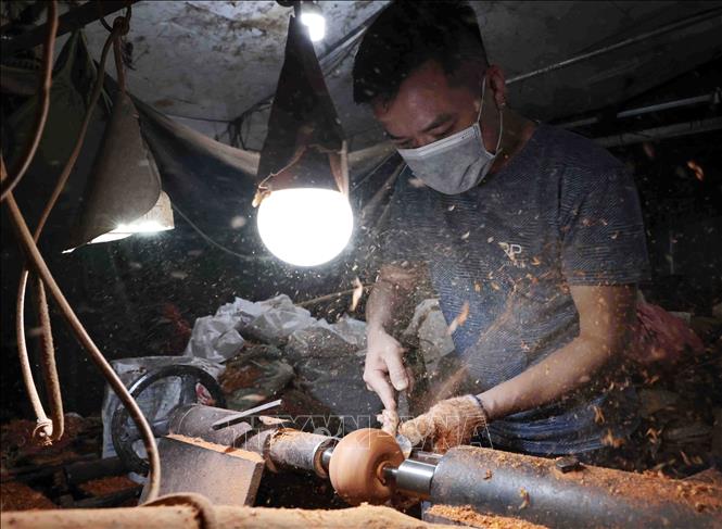 An artisan works with a wood lathe. VNA Photo: Trần Việt